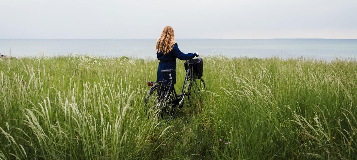 Kvinde med cykel ved Nordkyststien