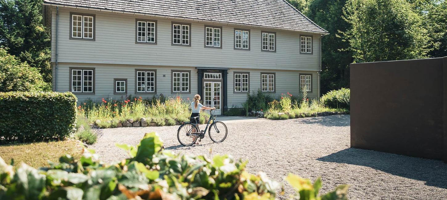 Kvinde med cykel ved Munkeruphus