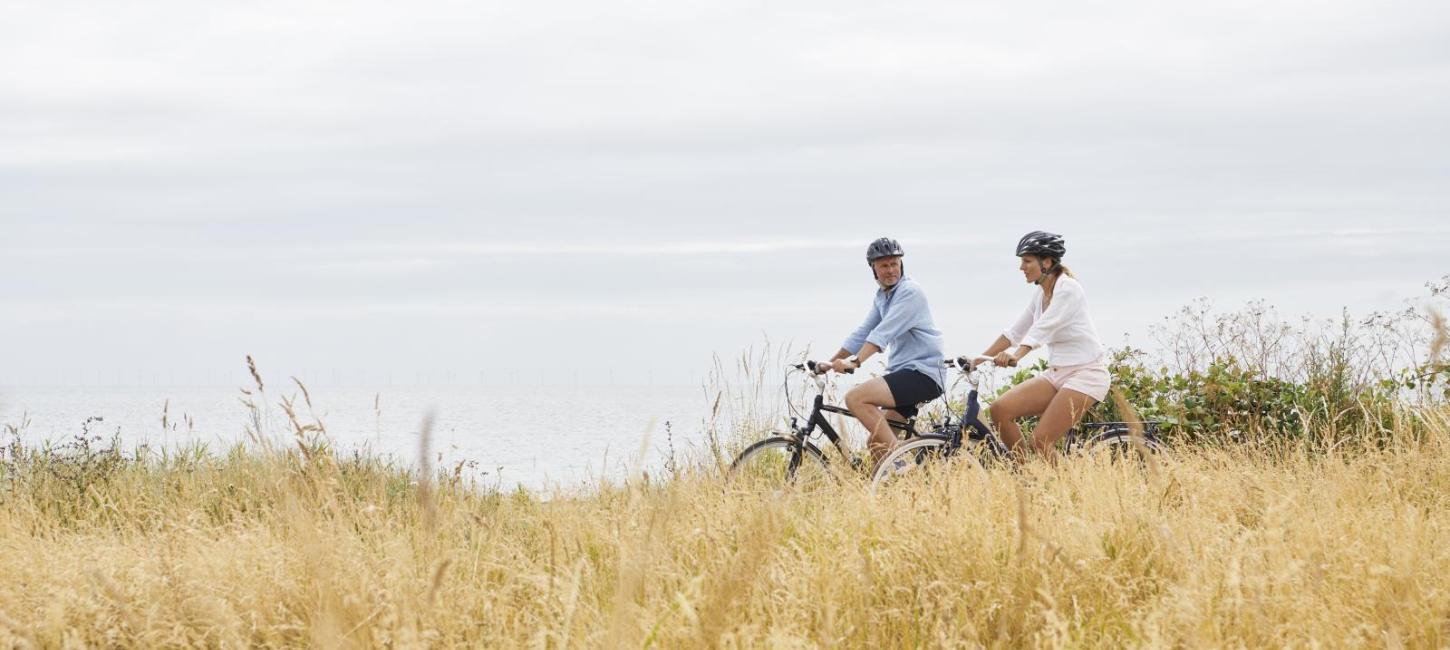 To cyklister kommer kørende langs en sti. 